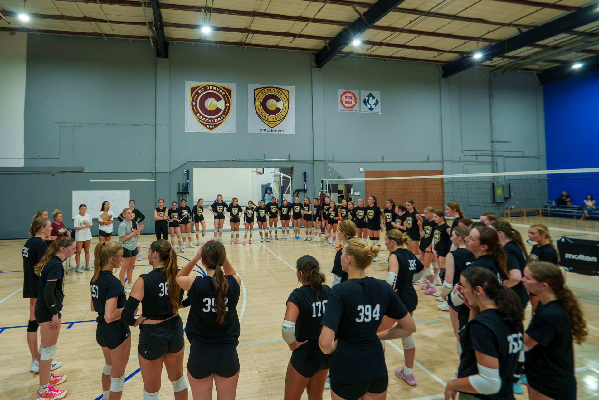 VC Denver athletes gathered across the volleyball court during a large club program
